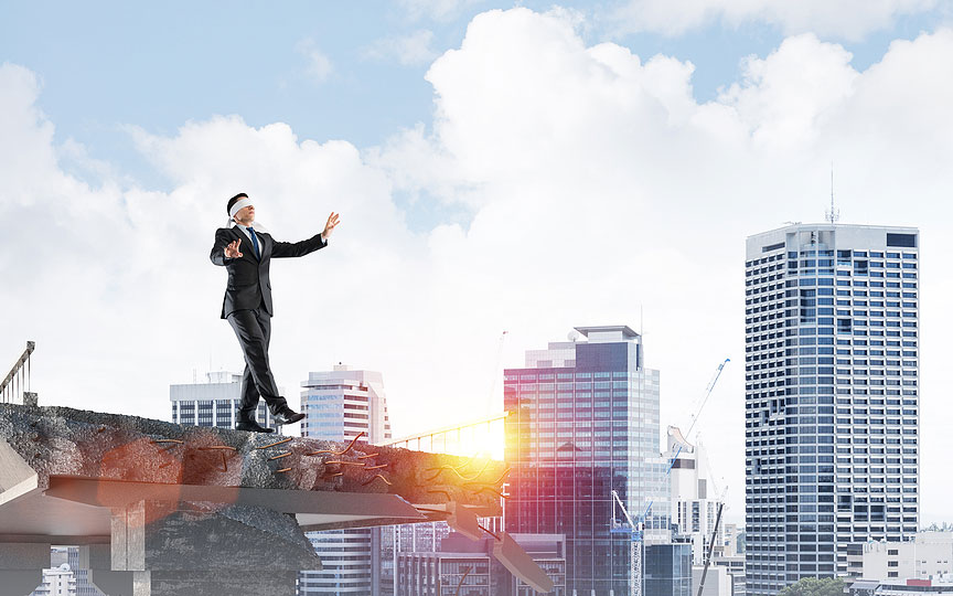 blindfolded businessman walking off bridge