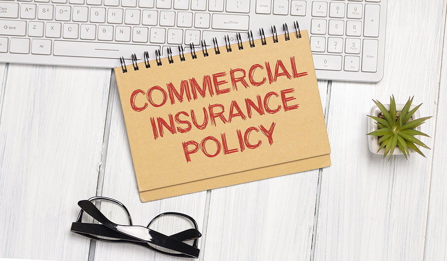 Commercial Insurance Policy on notepad near keyboard